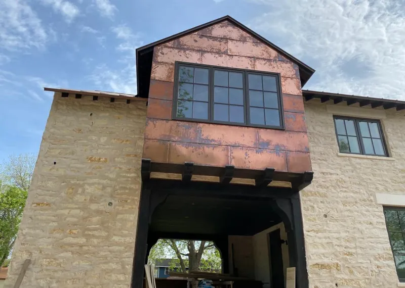 Copper metal panel facade on a stone building for Roof Repair in Myrtle Grove