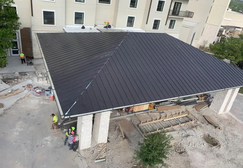 Metal roofing installation team working on a commercial building in Myrtle Grove